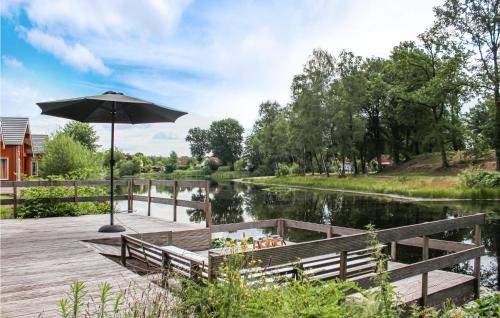 a bench with an umbrella next to a river at Lovely Home In Heel With Wifi in Heel