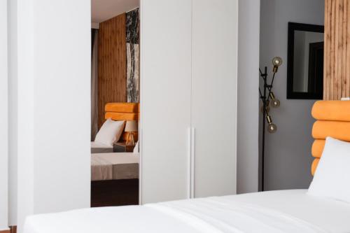 a bedroom with two beds and a mirror at Hotel Denis in Prizren