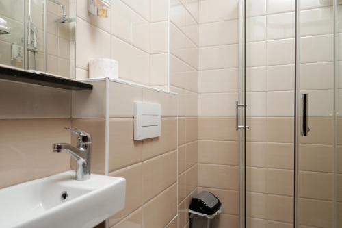 a bathroom with a sink and a shower at Hotel Denis in Prizren