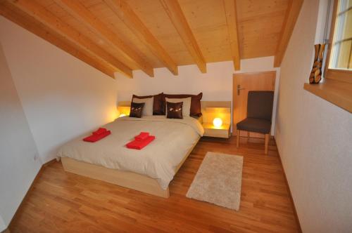 ein Schlafzimmer mit einem Bett mit zwei roten Kissen in der Unterkunft Luxury Penthouse Apartment in Lauterbrunnen