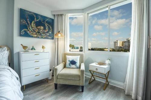 a bedroom with a bed and a chair and a window at GalleryOne Doubletree Hilton GC Turtle Cove in Fort Lauderdale