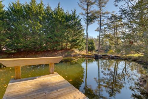 a wooden bench sitting on top of a body of water at 11 Mi to Ski Sapphire Heaven South Apt with Porch in Highlands
