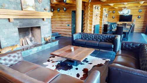 a living room with leather couches and a fireplace at Mountain Lake JBS in Focşani
