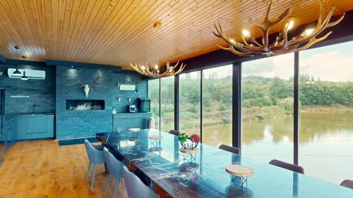 a dining room with a long glass table with chairs at Mountain Lake JBS in Focşani