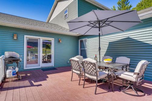 a patio with a table and chairs and an umbrella at Adirondack Retreat with Heated Pool and Scenic Views! in North Creek