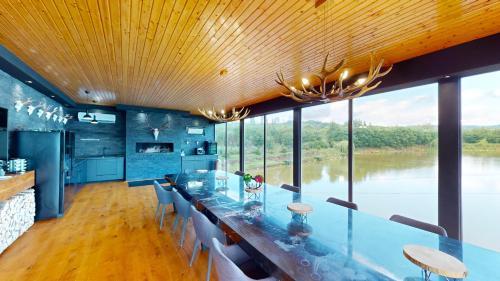 a dining room with a long glass table and chairs at Mountain Lake JBS in Focşani