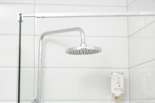a shower with a shower head in a bathroom at Hotel Denis in Prizren