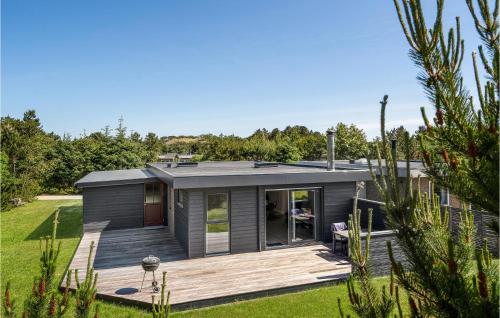 a modular home with a deck in a yard at Holiday Home Fyrgården Blåvand in Blåvand