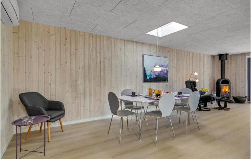 a dining room with a table and chairs and a fireplace at Holiday Home Fyrgården Blåvand in Blåvand