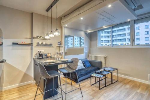 un salon avec une table et un canapé bleu dans l'établissement R'Apparts Studio Le Luxury N6, à Grenoble