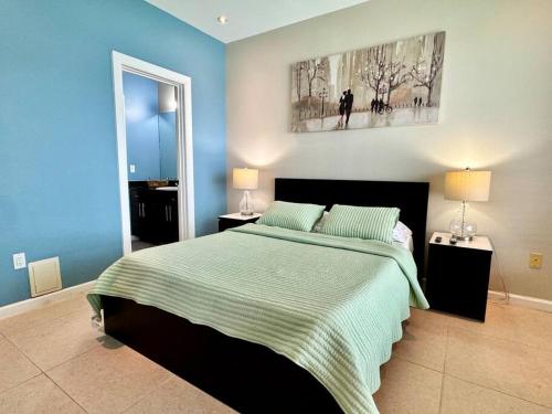 een slaapkamer met een groot bed en blauwe muren bij Luxury Condo with Pool and Jacuzzi in Mission