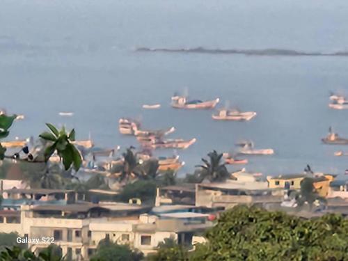 a group of boats in the water on a beach at Sea, Hill & Forest View Villa in Dongri
