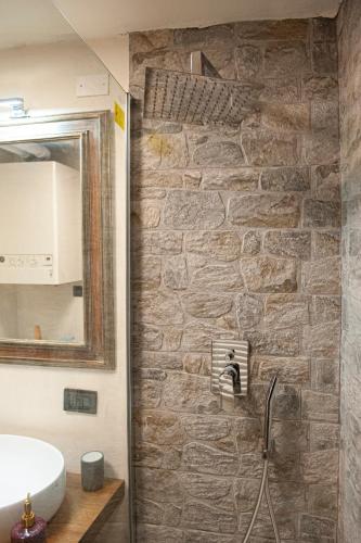 a bathroom with a sink and a stone wall at LA CASETTA in Vallo di Nera