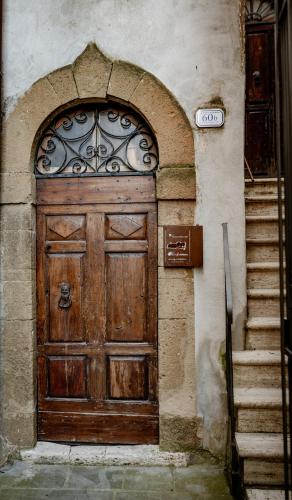 a large wooden door on a building with stairs at Neoclassico by Tiziana Monaldi in Pitigliano