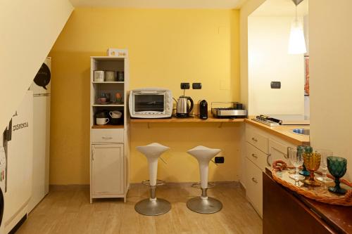a kitchen with two stools and a microwave on a counter at LA CASETTA in Vallo di Nera