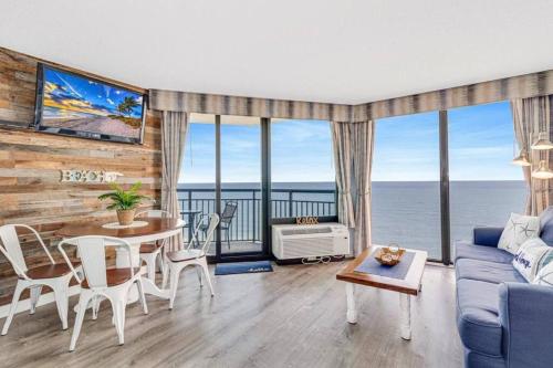 a living room with a blue couch and a table at Lux High-End Haven Oceanfront Suite! Dogs OK! 1606 in Myrtle Beach