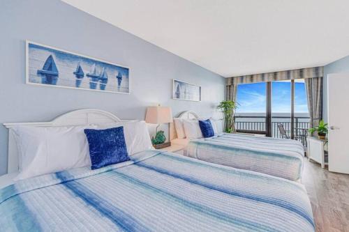 two beds in a bedroom with a view of the ocean at Lux High-End Haven Oceanfront Suite! Dogs OK! 1606 in Myrtle Beach