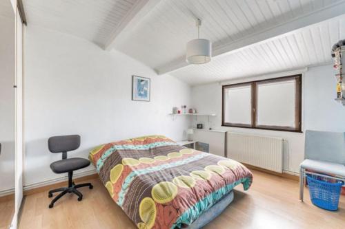 une chambre avec un lit, une chaise et une fenêtre dans l'établissement Charmante maison avec jardin proche bordeaux, à Bègles