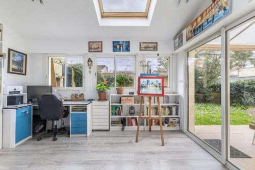 un bureau avec un bureau et un ordinateur dans une pièce dans l'établissement Charmante maison avec jardin proche bordeaux, à Bègles