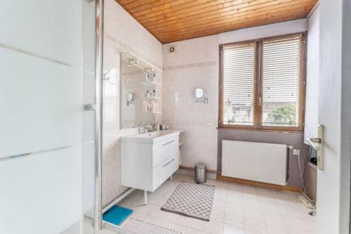 une salle de bain blanche avec une douche et un lavabo dans l'établissement Charmante maison avec jardin proche bordeaux, à Bègles