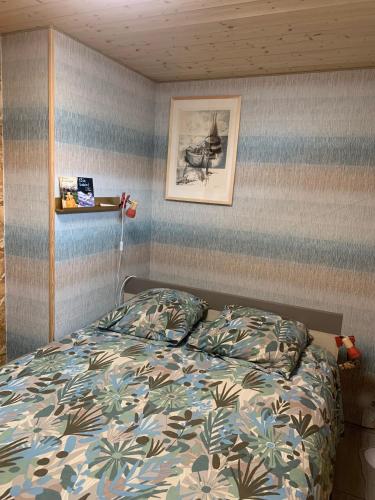 une chambre avec un lit et un tableau au mur dans l'établissement Maisonnette centre de Fouras, à Fouras