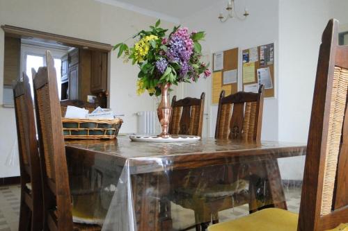 a table with a vase of flowers on it at meublé de tourisme familial bord de plage in Saint-Laurent-sur-Mer