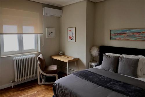 a bedroom with a bed and a desk and a window at VUT PLAZA DEL ANGEL in Salamanca