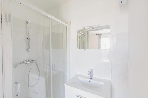 un bagno bianco con lavandino e doccia di Le Botanique "By Cottage d'Auch" ad Auch