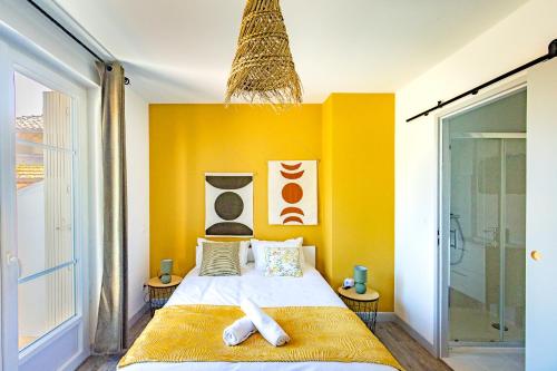 una camera da letto con un letto con una parete gialla di Le Botanique "By Cottage d'Auch" ad Auch