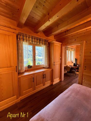 a bedroom with a large window in a log cabin at Alpenburg Bergparadies Apartments in Wald am Arlberg