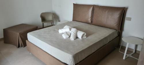 a bed with two white towels on top of it at La Dimora del Cuore in Mesagne