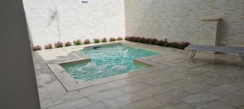 a swimming pool in the middle of a patio with a bench at La Dimora del Cuore in Mesagne