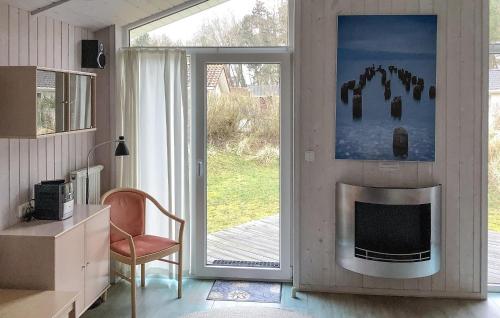 a living room with a fireplace and a sliding glass door at Freibeuterweg 23 - Dorf 5 in Travemünde