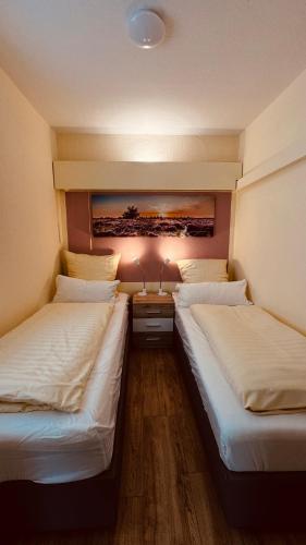 two twin beds in a room with two lamps at Ferienwohnung Am Mühlenbach in Bienenbüttel