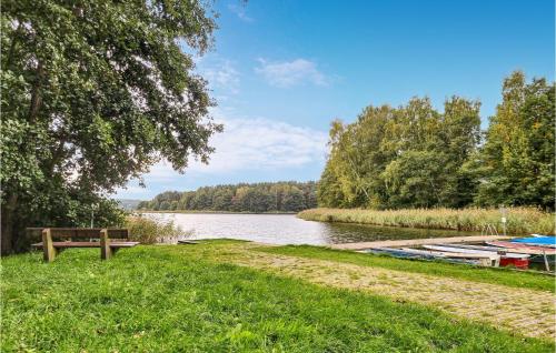 a bench next to a river with boats on it at Stunning Stacaravan In Lohmen Am See in Garden