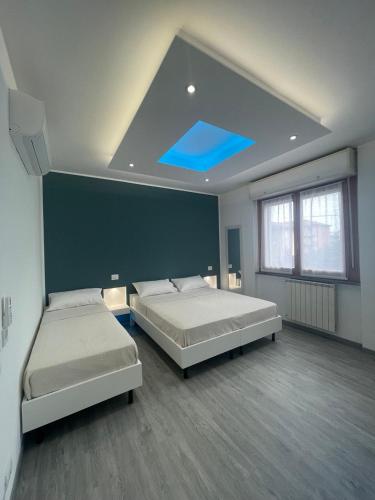 a bedroom with two beds and a blue ceiling at Lalas Room in Zanica