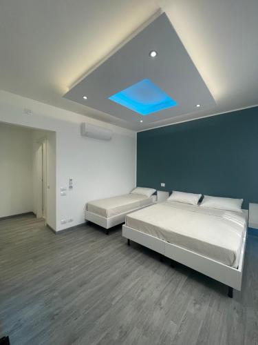 a bedroom with two beds and a blue ceiling at Lalas Room in Zanica