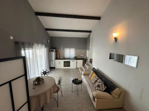 un salon avec un canapé et une table dans l'établissement Campagne Du Sud, 15 min de la Mer, à Villetelle