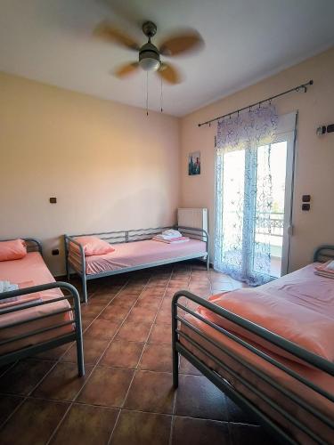 a room with two beds and a ceiling fan at Bella Vista in Dhíkella