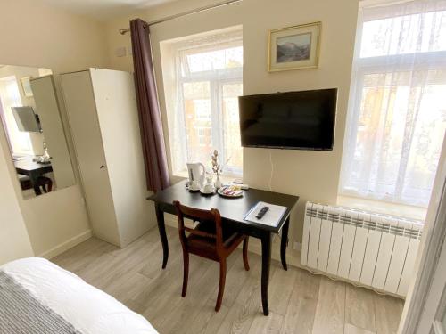 アリスバーリーにあるApartment with an Open-Plan Kitchen Living Roomのテーブル、テレビ、ベッドルームが備わります。