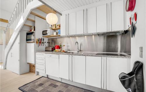 a kitchen with white cabinets and a sink at Holiday Home Havnevej in Vestervig