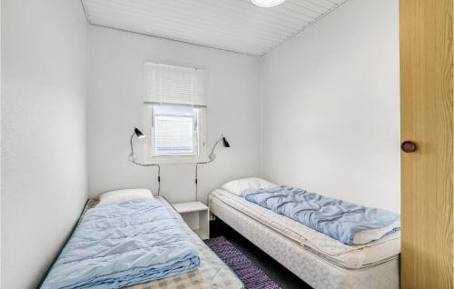 two beds in a small room with a window at Holiday Home Havnevej in Vestervig