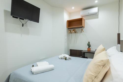 a bedroom with a bed with a tv on the wall at San Giusto Rooms in Giardini Naxos