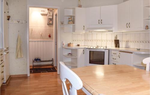 a kitchen with white cabinets and a wooden table at Stunning Home In Hultsfred With Sauna in Hultsfred
