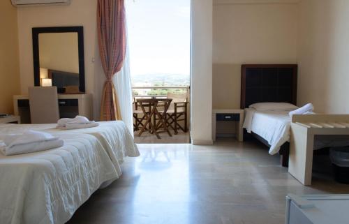 a hotel room with two beds and a table at GOLDEN SUN Κokkoni Beach Hotel in Vrahati