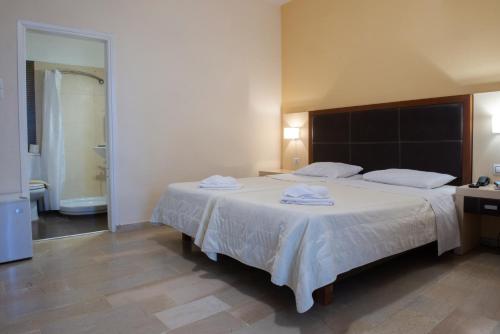 a bedroom with a large bed with towels on it at GOLDEN SUN Κokkoni Beach Hotel in Vrahati