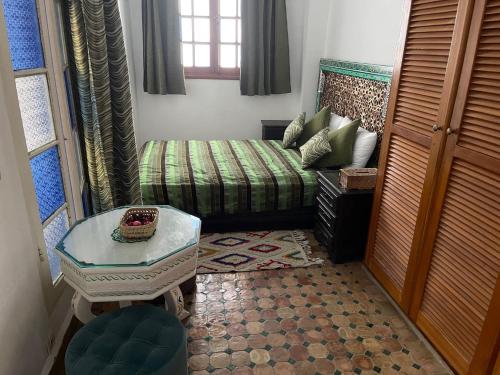 a living room with a couch and a table at Riad Aicha in Asilah