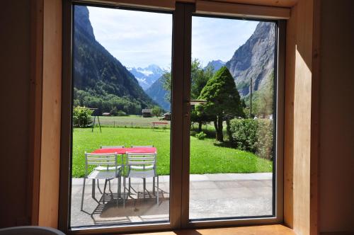 a view of a table and chairs from a window at Waterfall Chalet in Stechelberg