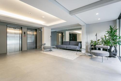 a lobby with a couch and chairs in a building at Studios Rio Branco by Viva - Prédio moderno, aptos com cama king-size no centro de Floripa in Florianópolis