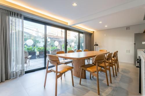 a dining room with a wooden table and chairs at Studios Rio Branco by Viva - Prédio moderno, aptos com cama king-size no centro de Floripa in Florianópolis